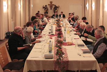 Gruppen und Kreise Die Mitglieder eines Pfarrgemeinderates und eines Presbyteriums treffen sich zu einer gemeinsamen Sitzung und feiern zusammen eine Agape