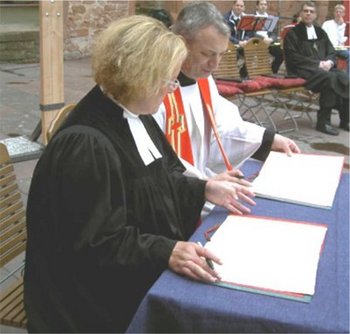 40 Jahre Ökumenischer Arbeitskreis Der katholische Pfarrer und die protestantische Pfarrerin von Bad Dürkheim unterzeichnen eine Partnerschaftsvereinbarung der beiden Gemeinden