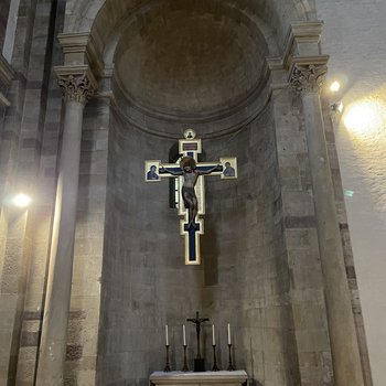 Großes Holzkruzifix mit goldenem Hintergrund in Apsisnische hängend