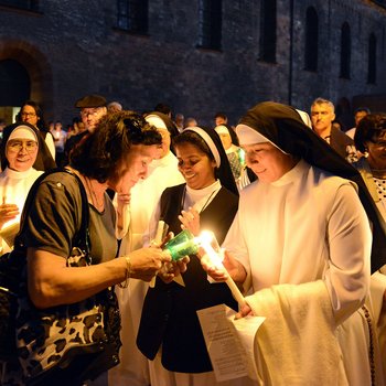 Gottesdienstteilnehmerin entzündet Kerze