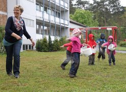 Kindergartenkinder säen mit Arletta Groß, Leiterin der Sozialbetreuung, eine Blumenwiese.