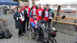 Gruppe von Menschen mit einem Rollstühl-Biker in der Mitte.