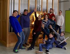 Junge Leute vor einer Orgel.