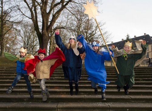 Sternsinger springen eine Treppe hinunter
