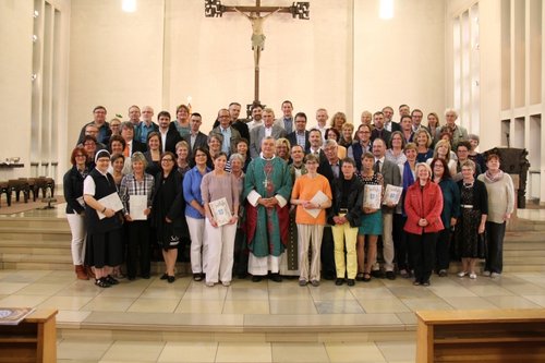 Ein große Gruppe von Frauen und Männern stehen im Altarraum der Klosterkirche in Esthal.